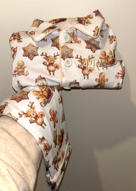 Children's pajama top with reindeer and gingerbread man pattern on a plain background