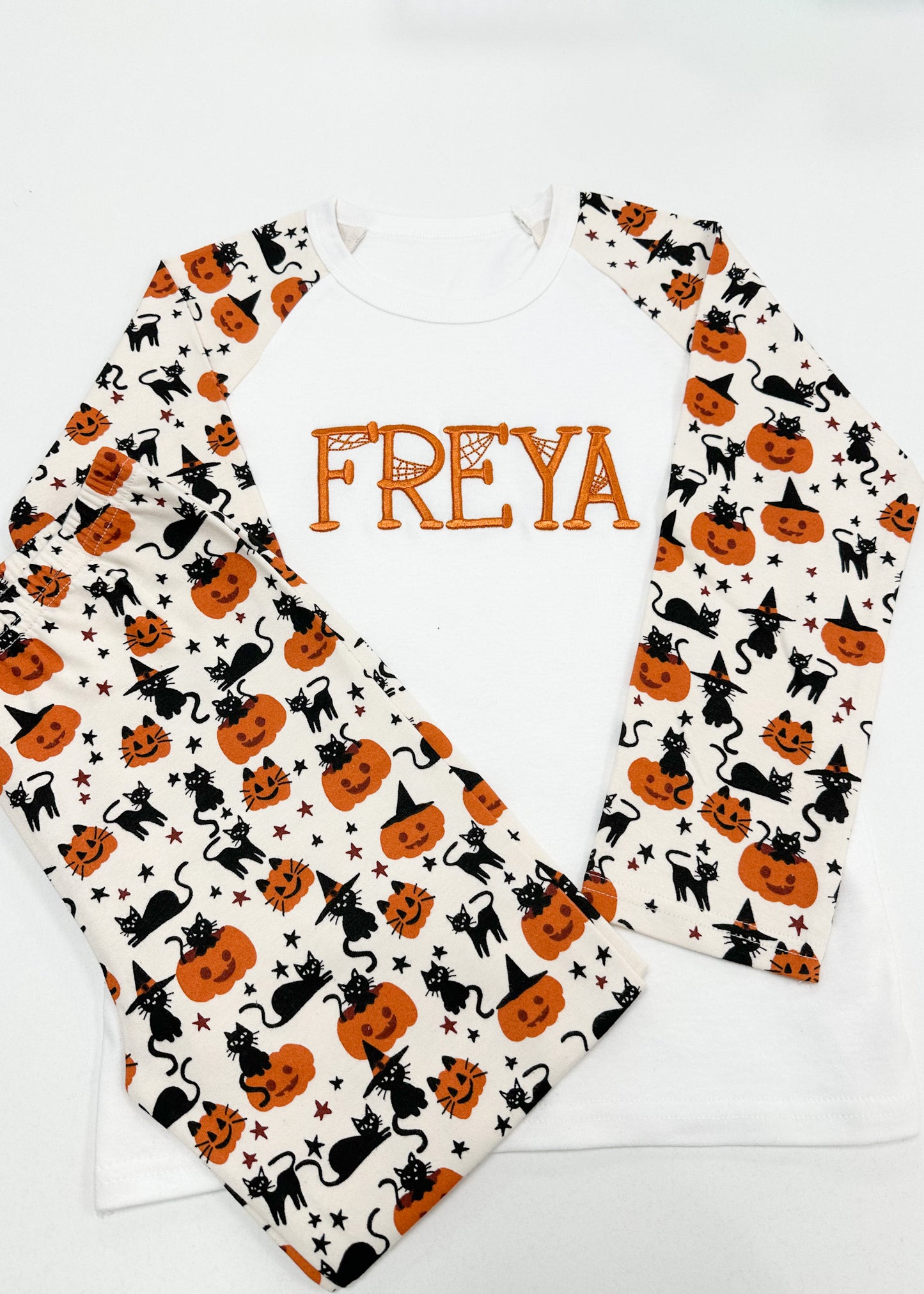 Two baby bibs with Halloween patterns and the name 'FREYA' on a white background