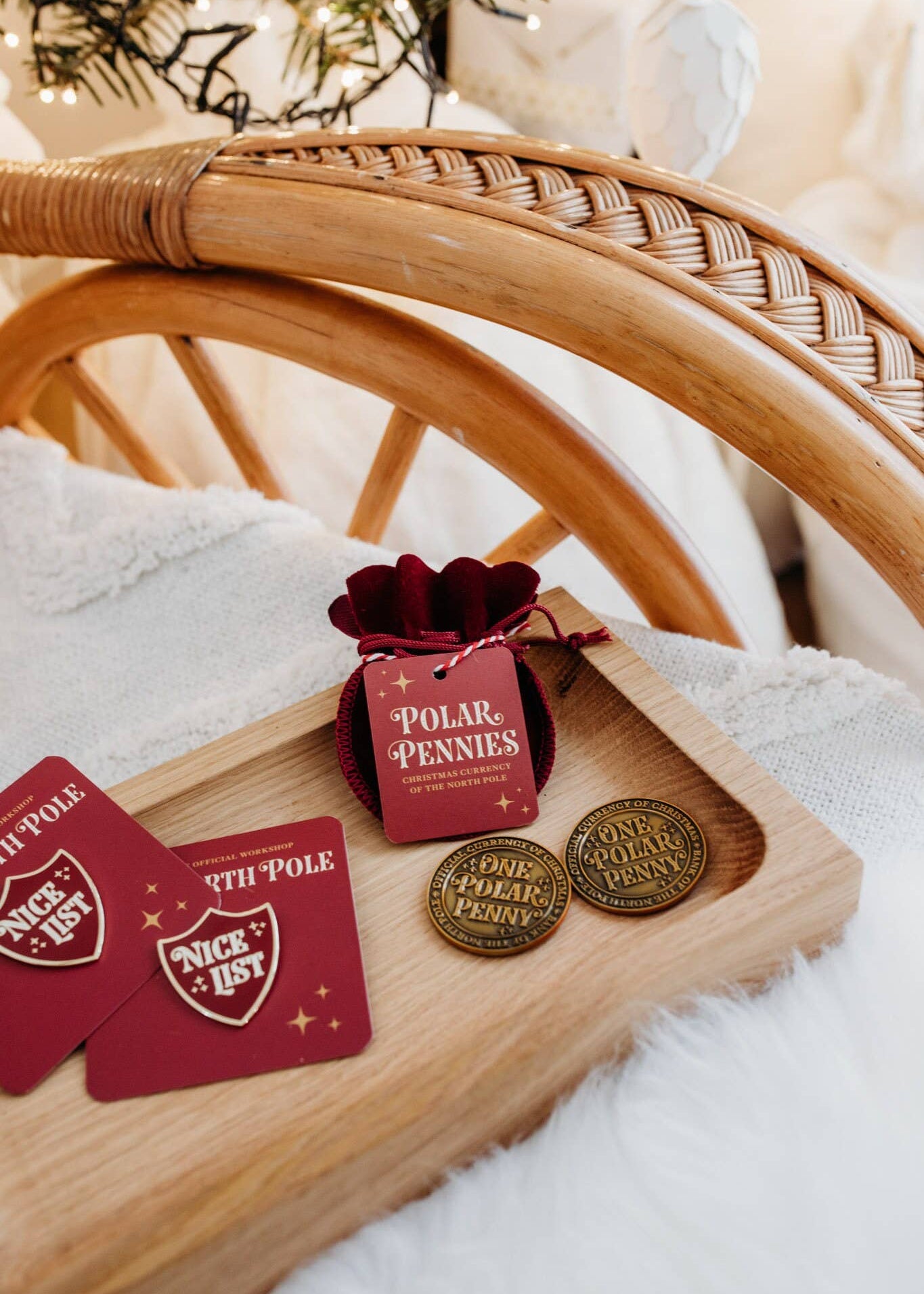 Wooden tray with 'Polar' themed items including cards, coins, and a small bag on a soft surface.