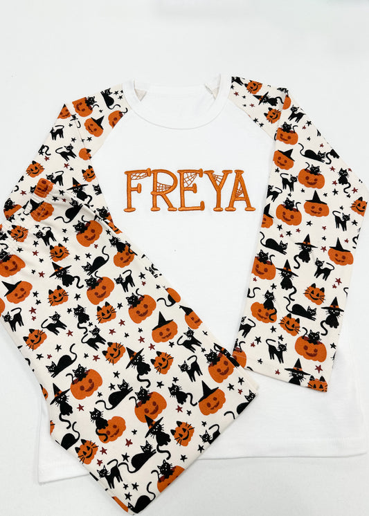 Two baby bibs with Halloween patterns and the name 'FREYA' on a white background